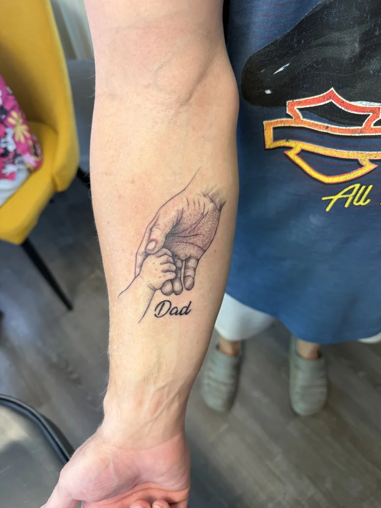 Dad memorial holding baby hand