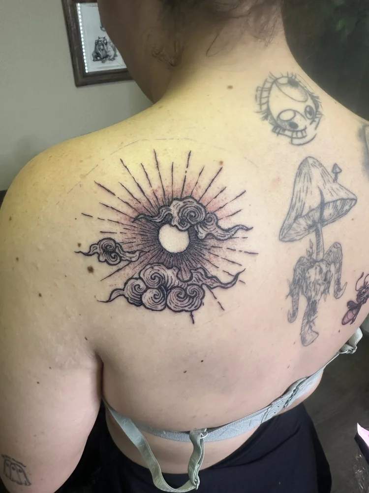 Sun and clouds back tattoo