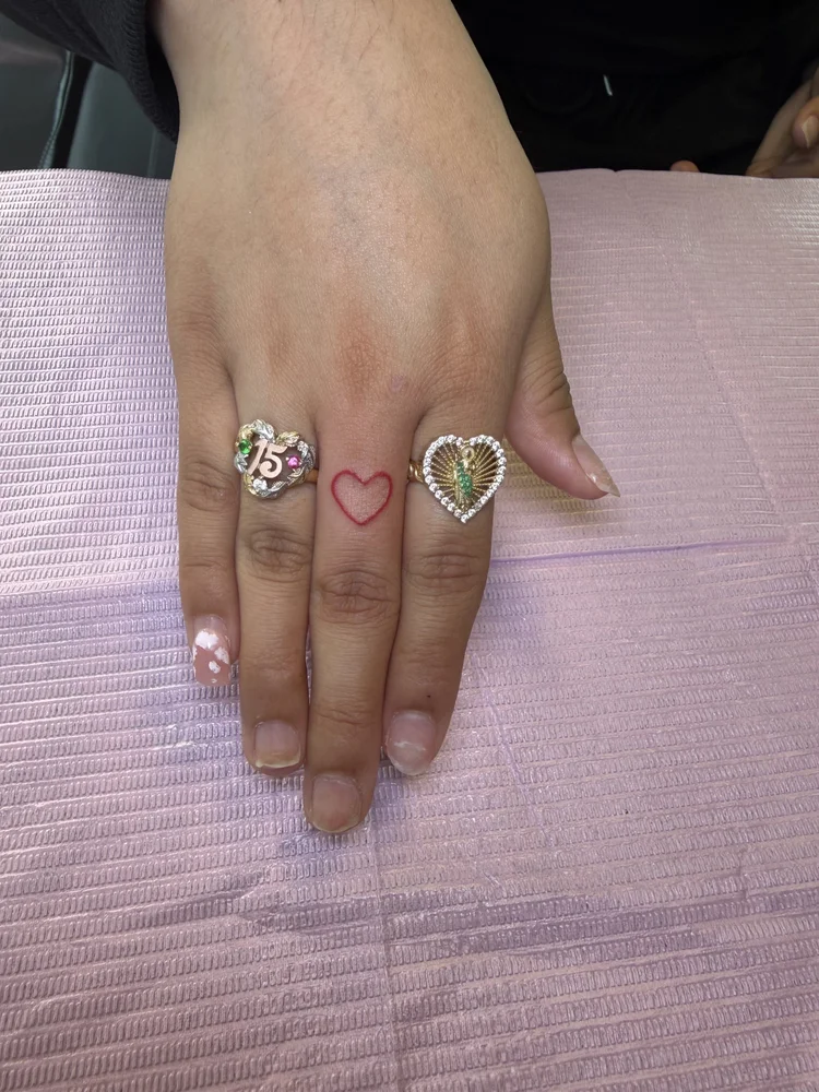 Red heart finger tattoo